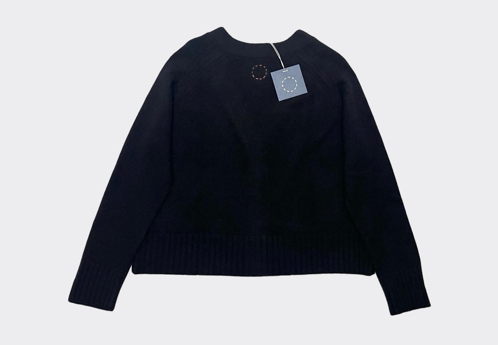 Back roduct flat lay of boxy black cashmere cardigan. Swing tag visible and circle of stitches logo from Irish knitwear brand Sphere One