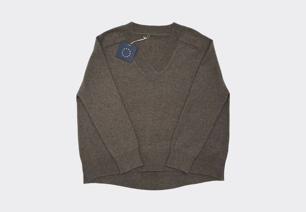 Front product shot brown V Neck saddle shoulders cashmere sweater with a curved back hem and navy Sphere One swing tag visible along with circle of stitches logo at the back neck