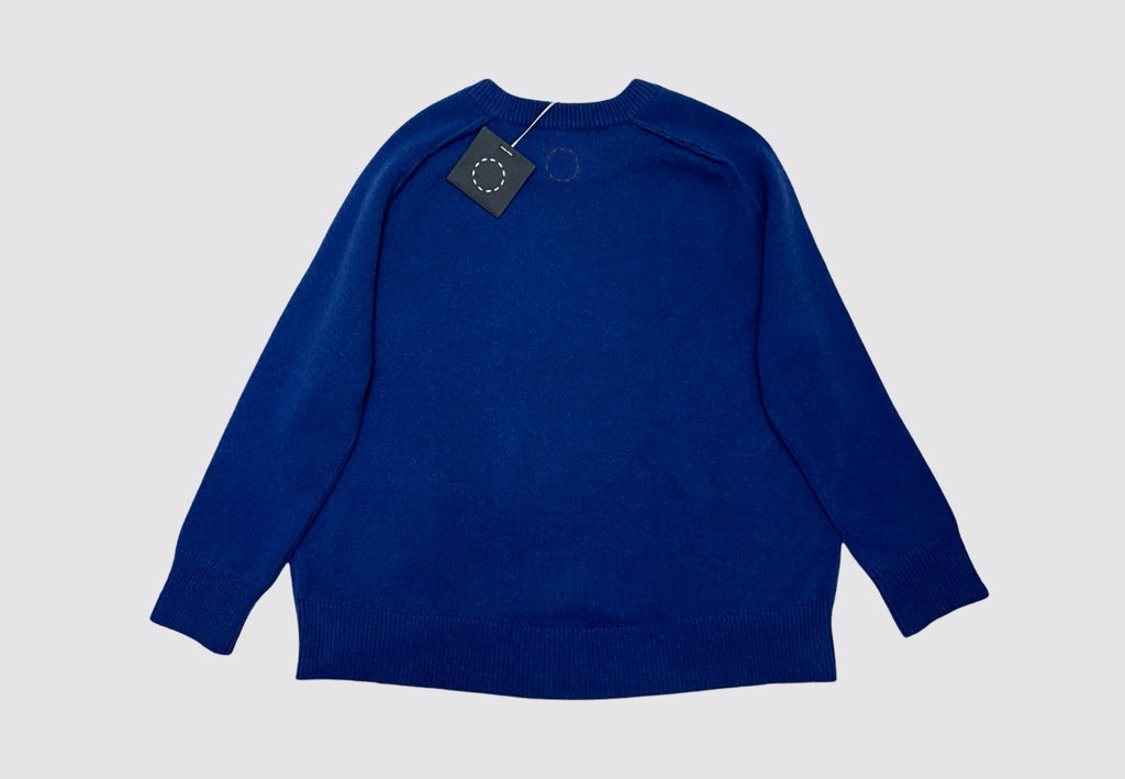 Front product shot blue cashmere oversized round neck sweater Irish knitwear label Sphere One. Circle of stitches logo and navy swing tag visible at the back neck.